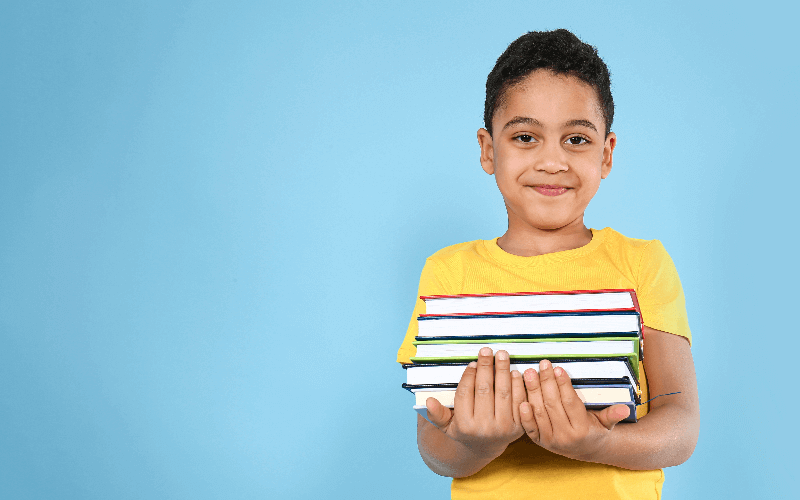 Latino boy holding books
