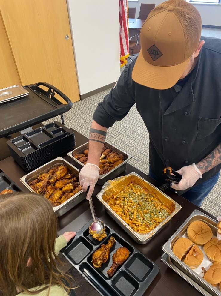server filling student's lunch tray with food samples