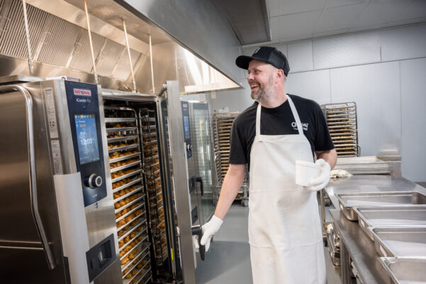 Food service worker opening door to Combi oven