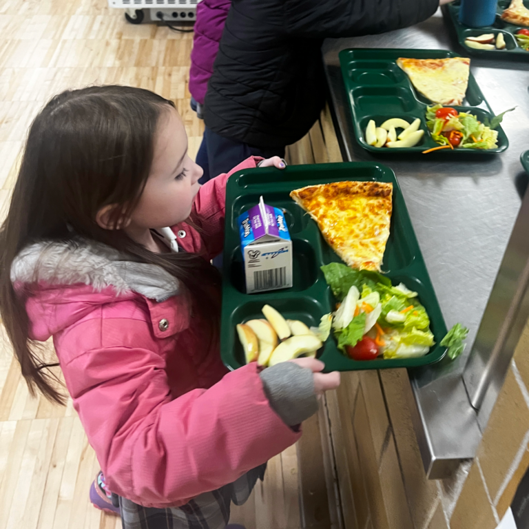 Child picking up tray with USDA-compliant pizza at St. Charles