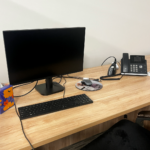 desk with computer, keyboard, mouse, and phone